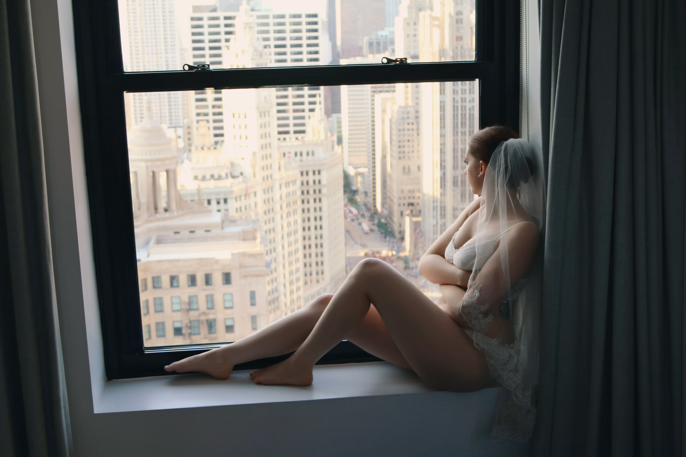 Boudoir bridal portrait by a large window overlooking skyline; remove blemishes and redness, enhance delicate highlights