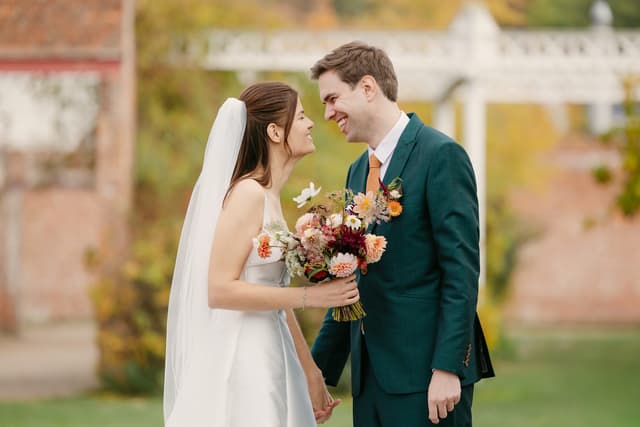 Bride and groom smiling nose-to-nose in a garden, color correction and gentle color grading, skin retouching with natural texture
