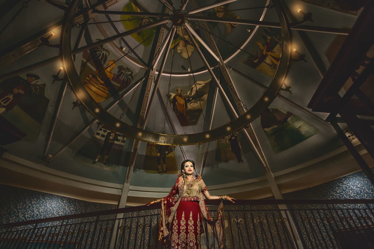 Bride in red dress under a domed ceiling, challenging lighting corrected, color correction for dramatic tones, and background cleanup for symmetry