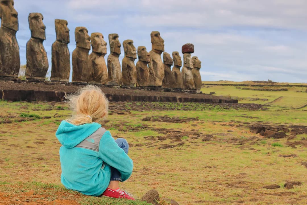 Child sitting in front of Moai statues on Easter Island; color correction, natural and accurate color balancing, and background cleanup