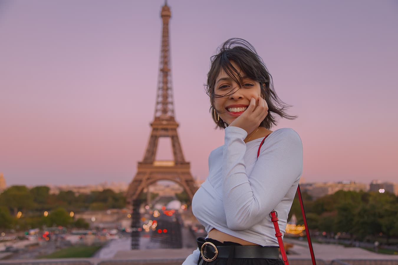Smiling woman portrait with the Eiffel Tower at sunset; skin and beauty retouching, hair and eyes enhancement, and color correction