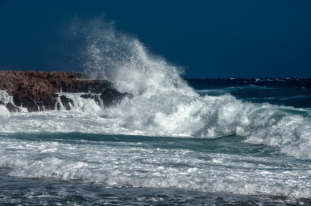 Powerful ocean waves crashing on rocky coast; color correction, natural and accurate color balancing, and background cleanup