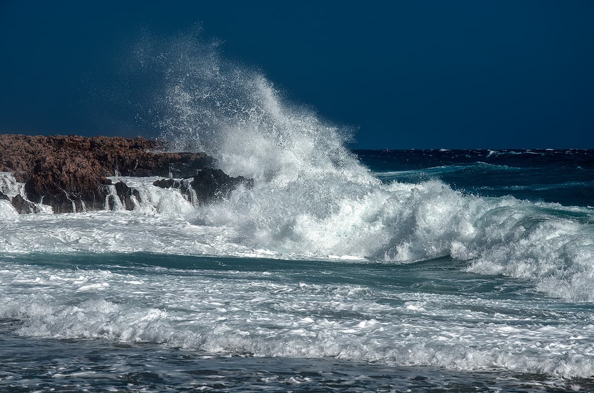 Powerful ocean waves crashing on rocky coast; color correction, natural and accurate color balancing, and background cleanup