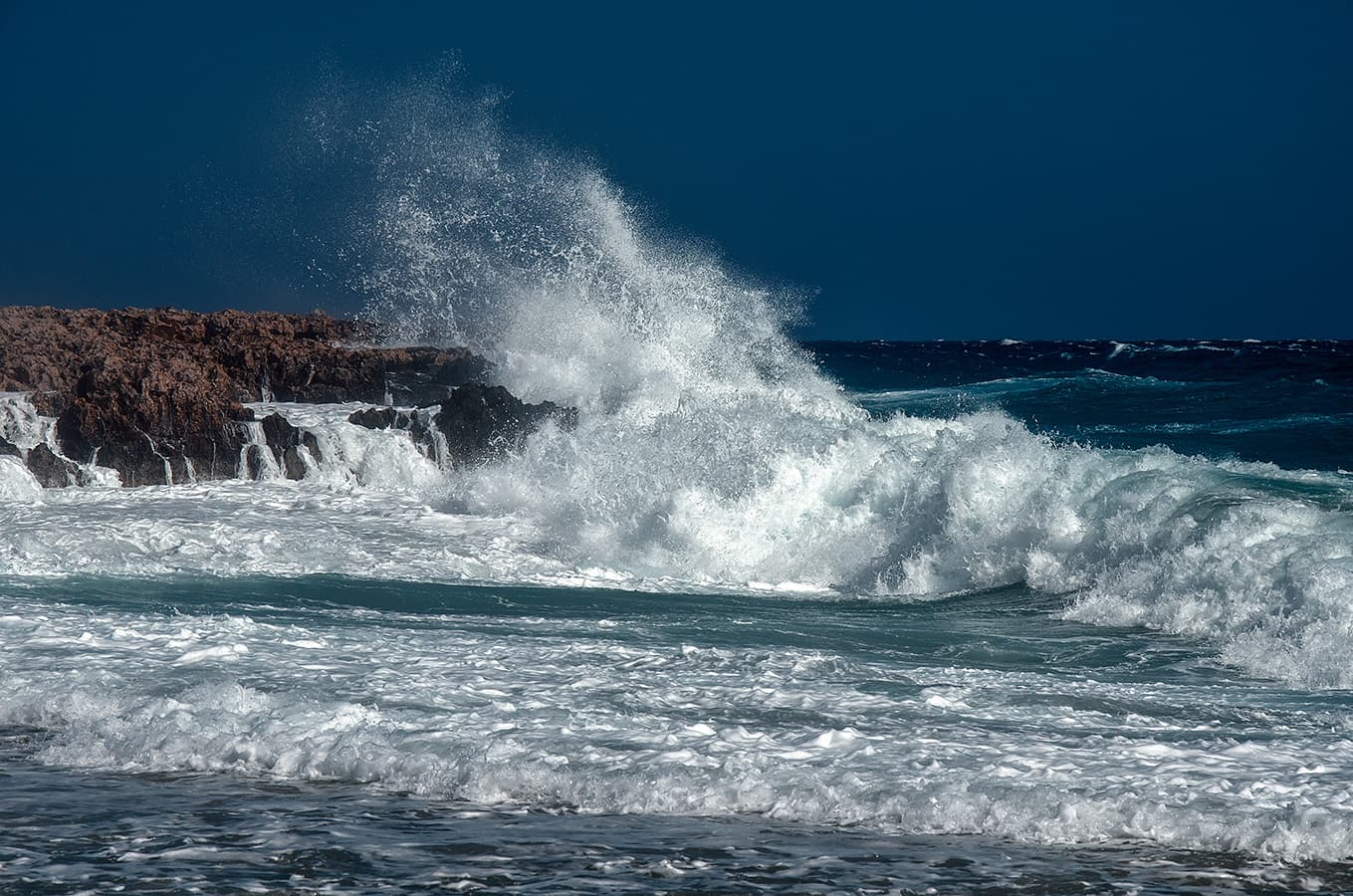 Powerful ocean waves crashing on rocky coast; color correction, natural and accurate color balancing, and background cleanup